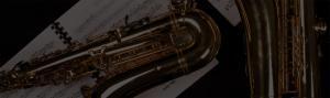 Gold alto and tenor saxophones laying on sheet music